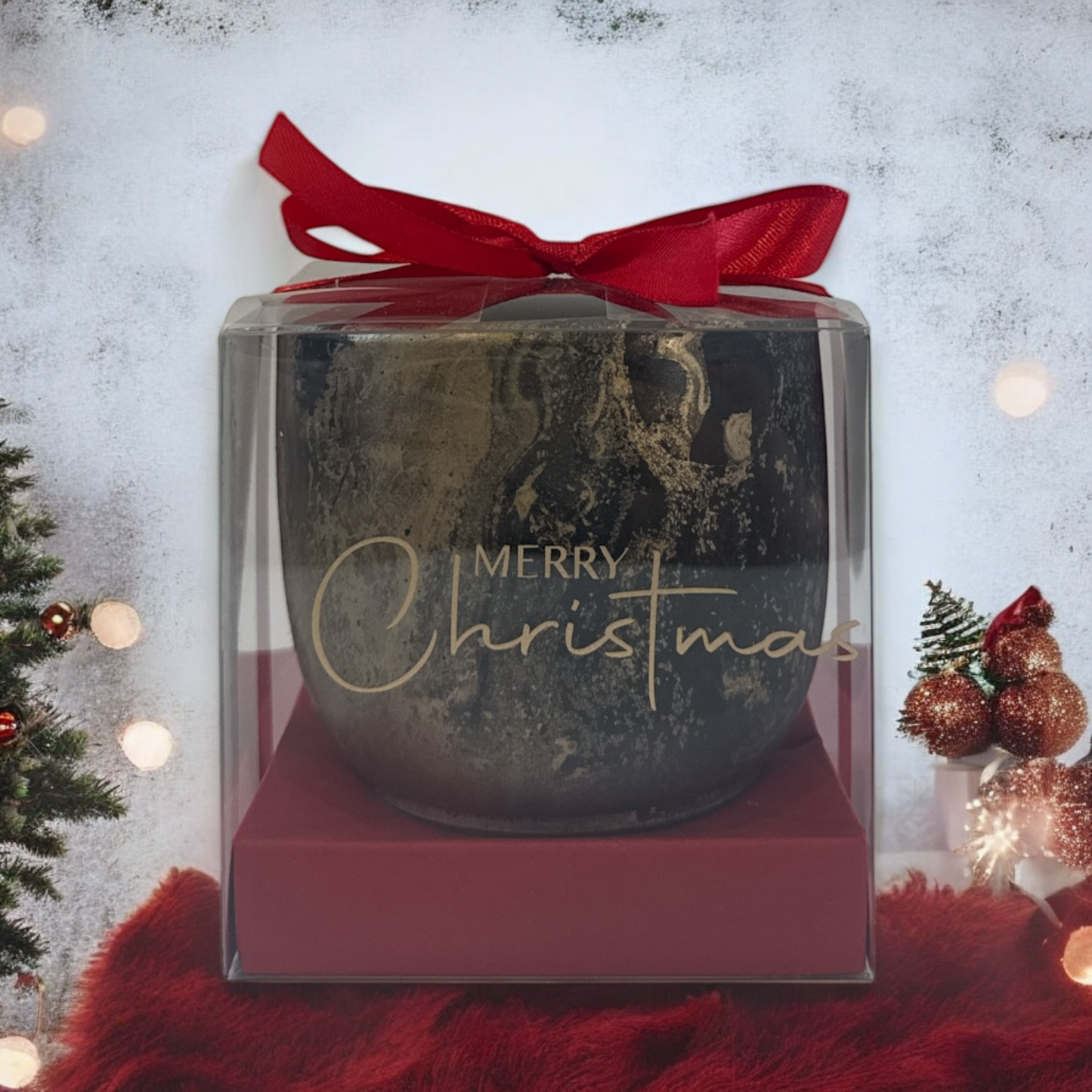 Decorative Christmas ornament in a clear box with a red ribbon on a festive background.