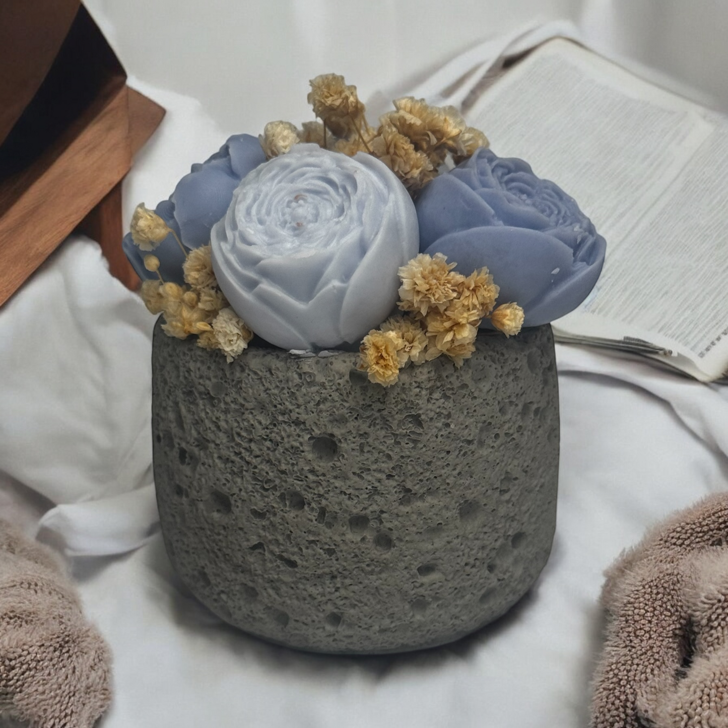 Artisan concrete candle with realistic wax flower arrangement, reusable vessel for plants or décor.